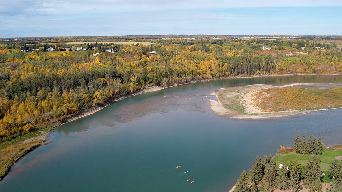 Two red canoes on the shore of the North Saskatchewan River near Big Island Provincial Park and Rivers Edge in West Edmonton